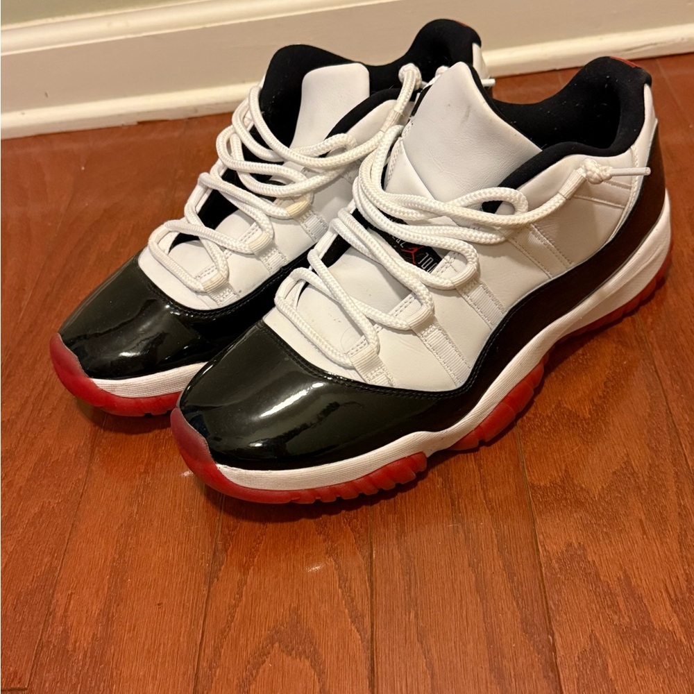 Air Jordan 11 Retro “Concord-Bred” Black and White Sneakers with Red Soles